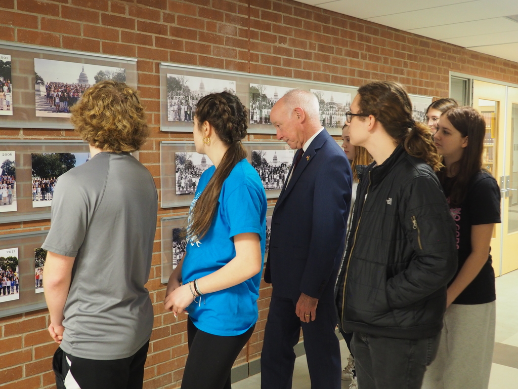 Courtney and students looking as wall of DC visit class photos